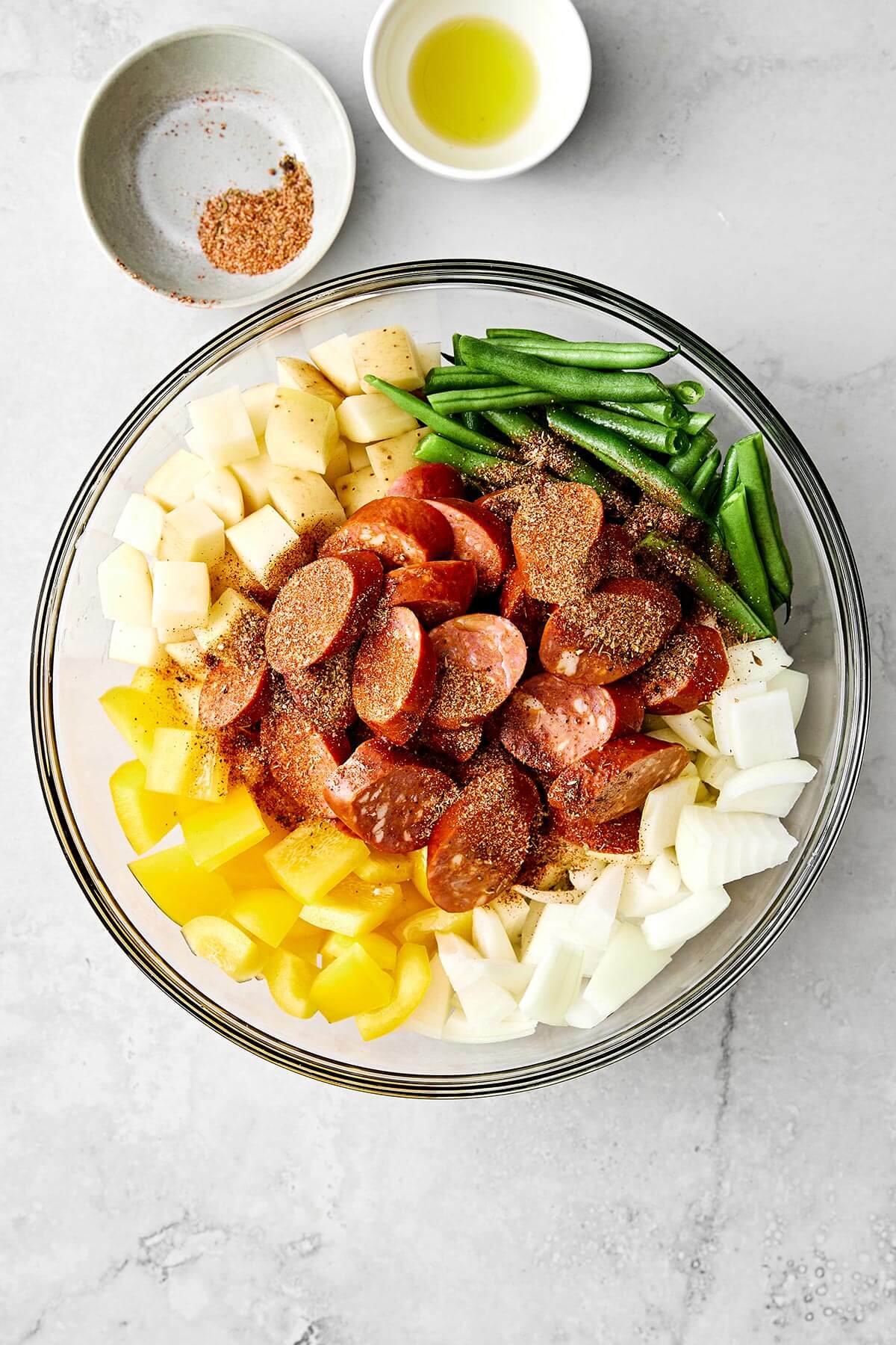 Mixing ingredients for Cajun sheet pan meal.